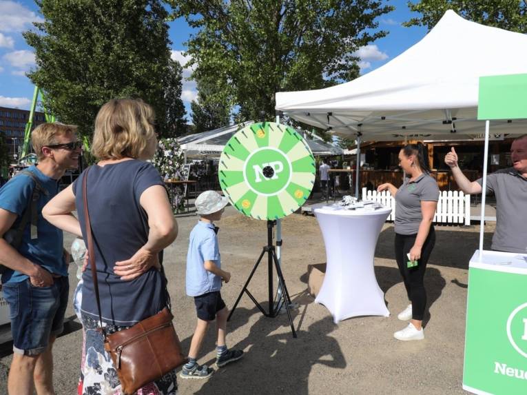 Menschen vor einem Stand.